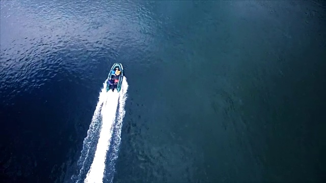 空中鸟瞰图追赶摩托艇在平静的河上快速移动视频下载