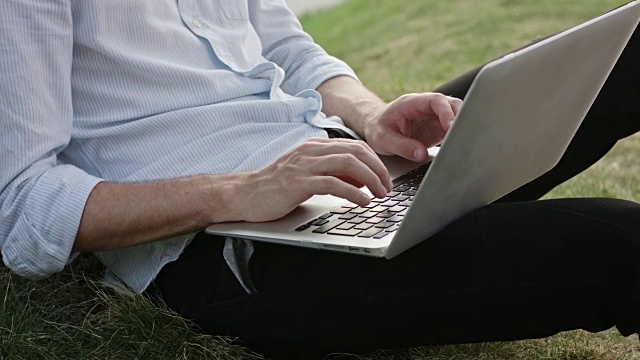 一个年轻人在户外使用笔记本电脑视频素材