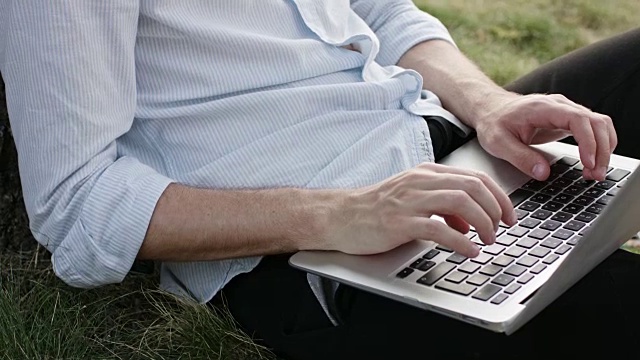 一个年轻人在户外使用笔记本电脑视频素材