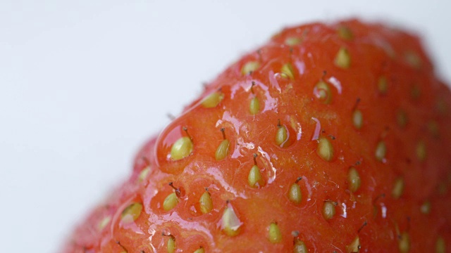 近距离观察:甜美的红色草莓果实中的小种子。雨在浆果视频下载