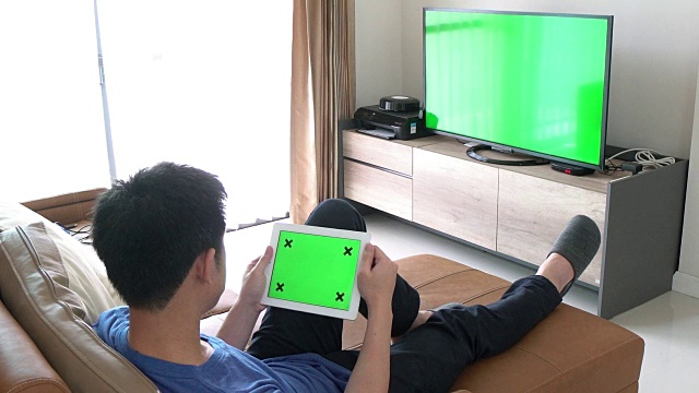 一个人在玩绿色屏幕的数字平板电脑视频下载