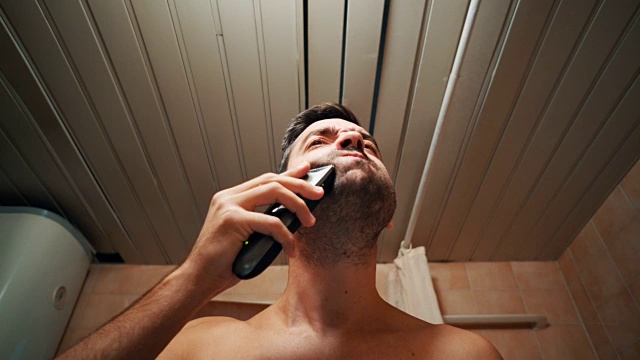 男人用电动剃须刀刮胡子视频素材