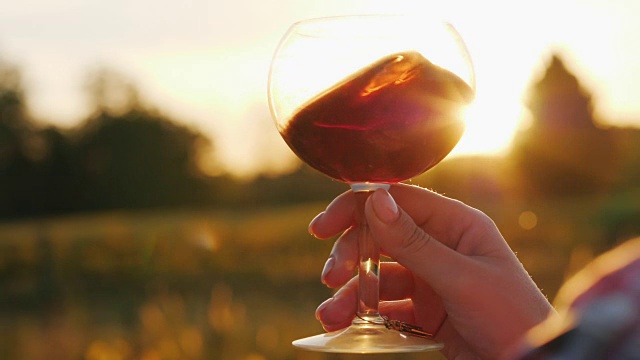 日落时分品酒。灯光照在一杯红酒上，美极了视频素材