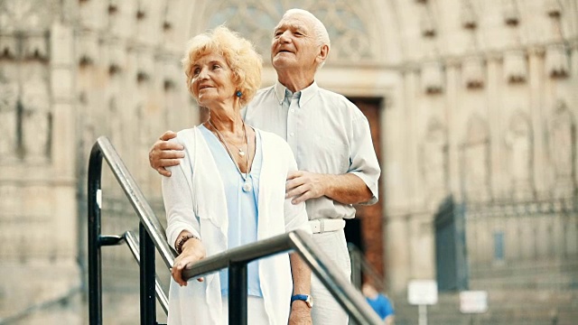 一对老年夫妇站在铁栏杆旁视频素材