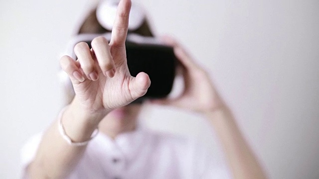 女人戴着虚拟现实模拟器耳机在白色背景视频下载