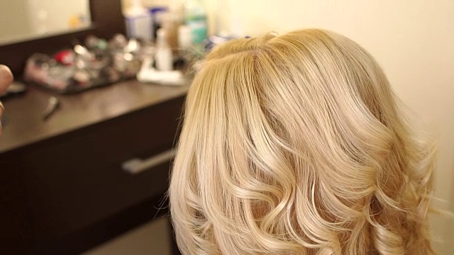 理发师在女孩的头发上喷发胶。视频下载