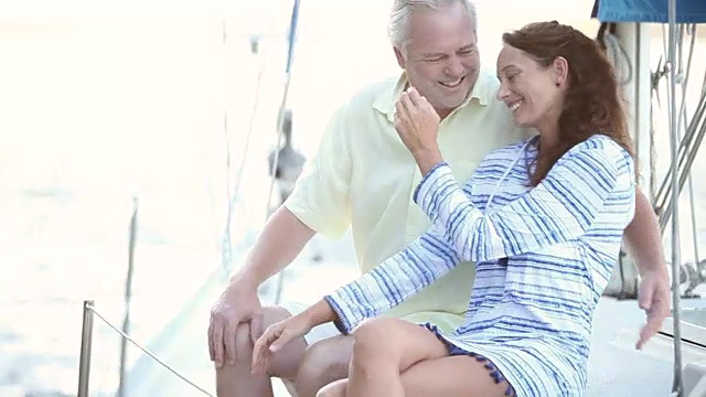 一对成熟的夫妇一起坐在帆船的甲板上视频下载