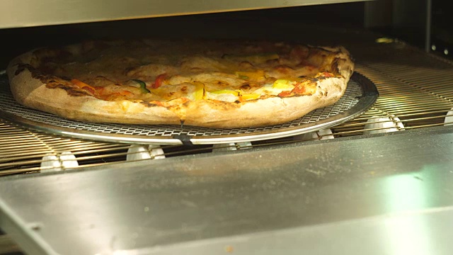 披萨取出自动烤箱，奶酪融化。视频素材