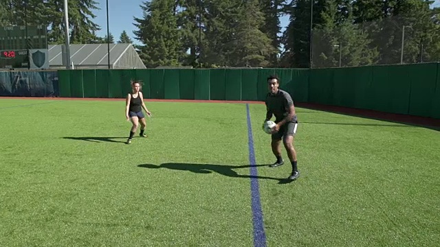 年轻男女在球场上进行球类运动视频素材