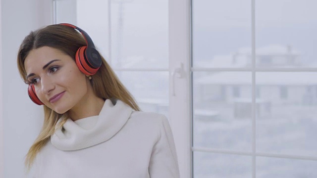 漂亮的长发女孩戴着耳机听音乐视频素材