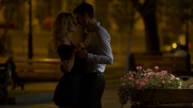 美丽的夫妇在公园温柔地拥抱和亲吻，晚上的约会，爱视频素材