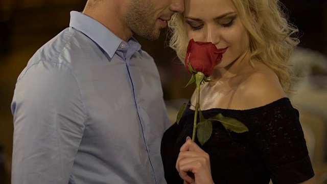 两个迷人的人的浪漫约会，女人抱着玫瑰和亲吻男友视频下载