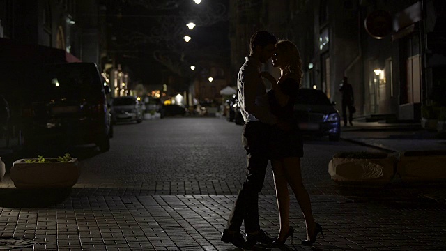 两个相爱的人在夜晚的街道上温柔地接吻，在大城市里相爱，约会视频素材