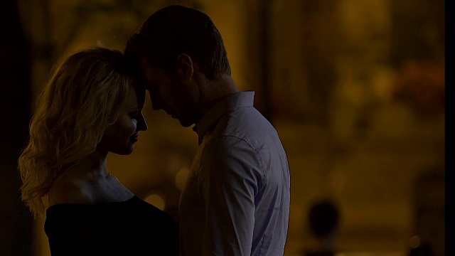 年轻的情侣在夜晚的街道上拥抱和依偎，浪漫的约会后散步视频素材