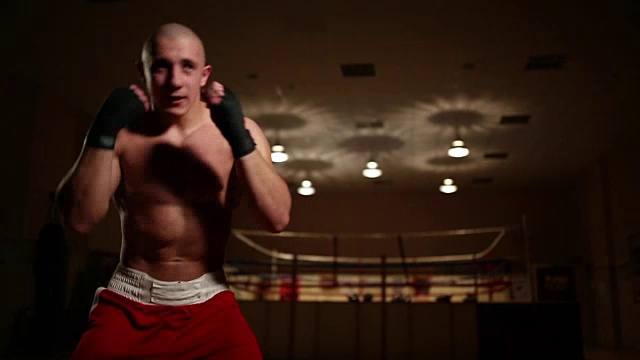 一名职业拳击手在擂台的背景中持有近距离的阴影，摄像机运动视频下载