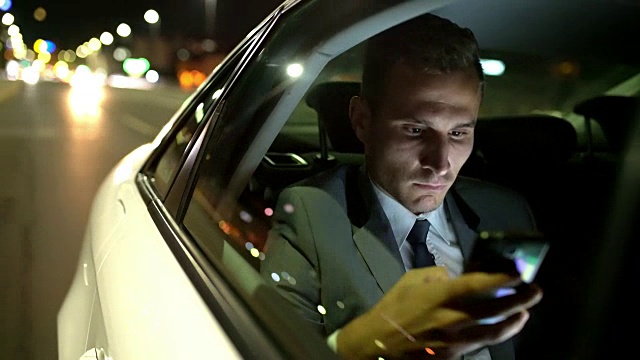 在豪华轿车的后座上使用智能手机的MS Businessman视频下载