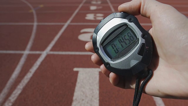 在跑步比赛、运动挑战赛中，裁判将时间标在秒表上视频素材