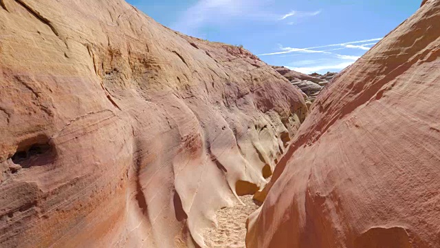 在一个干燥的峡谷与平滑和波浪形的岩石上的摄像机运动的红色峡谷4K视频下载