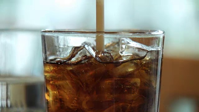 高清超级慢动作:将可乐放入装有冰块的杯子中视频素材