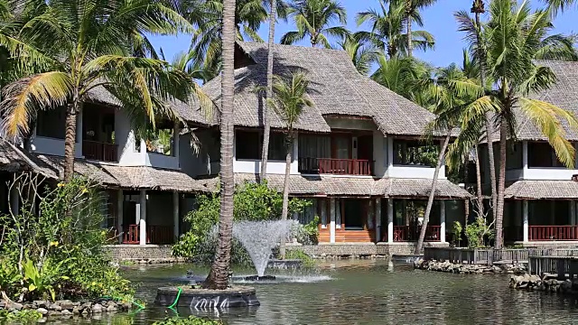 池塘，椰子树，喷泉和海边的热带小屋。Ngapali,缅甸,缅甸视频下载