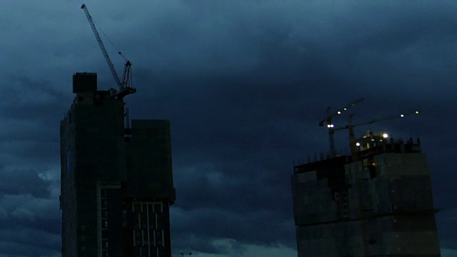 塔吊和在建高层建筑黄昏时的延时。高层建筑。住宅综合体、房地产业。视频素材