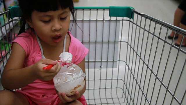 可爱的女孩在手推车上吃冰淇淋，视频下载