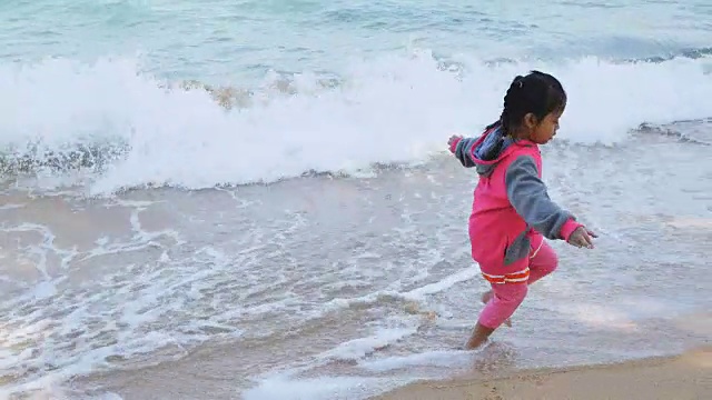 小女孩在海滩上玩海浪视频下载