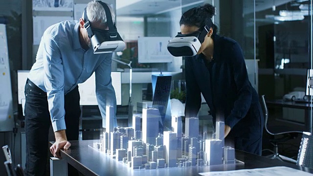 戴着增强现实头盔的男女建筑师使用3D城市模型工作。高科技办公专业人士使用虚拟现实建模软件的应用。视频素材