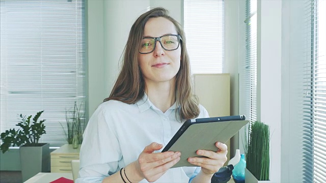 一个女商人拿着平板电脑的肖像。视频下载