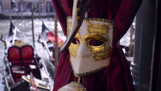 威尼斯狂欢节面具以黄金装饰，以威尼斯的大运河和贡多拉为背景。浪漫的威尼斯视频素材