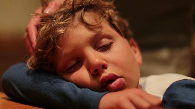 孩子睡觉。真实的父亲哄6岁儿子睡觉的真实时刻。精疲力竭的孩子在睡觉时被抱到床上视频购买