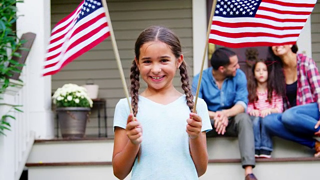 和家人在屋外举着美国国旗的女孩视频下载