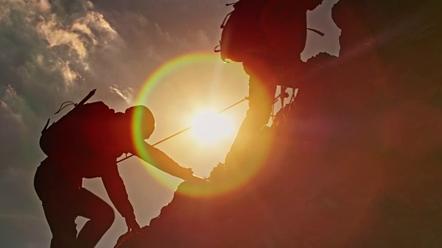两个登山运动员在太阳的耀斑中爬山视频下载