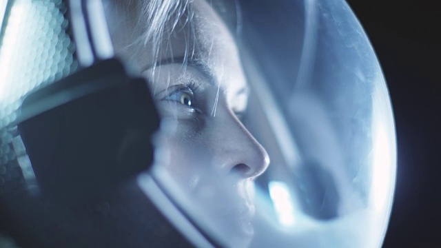 肖像拍摄的勇敢的女宇航员戴着头盔在太空中，环顾四周的奇迹。太空旅行，探索和太阳系殖民概念。视频下载