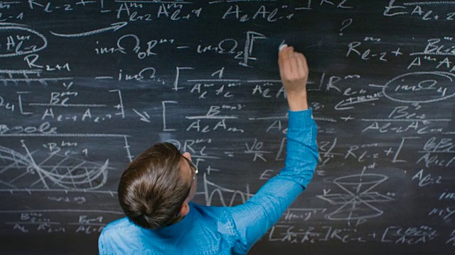 一位才华横溢的年轻学生在黑板上写复杂的数学公式。视频下载