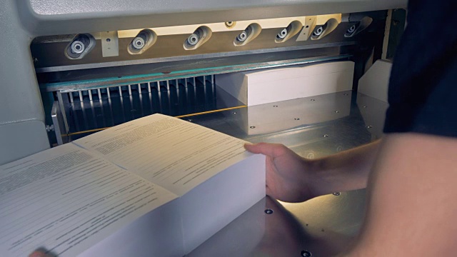 工业切纸机从纸上切下额外的纸。视频素材