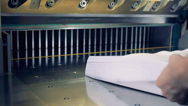 工人将纸放入切纸机。4 k。视频素材