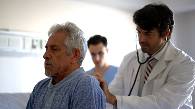忧心忡忡的医生一边用听诊器检查病人的肺部，一边对护士口授一些东西视频下载