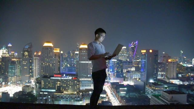 商业使用笔记本电脑和数字平板电脑在摩天大楼的背景视频下载