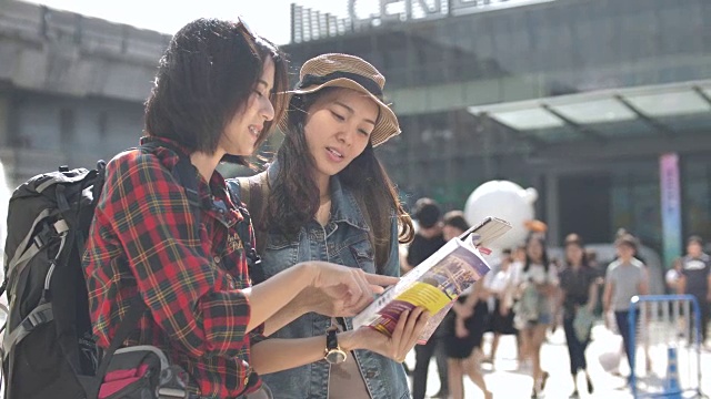 游客在城市中与朋友使用导游手册中的地图视频下载