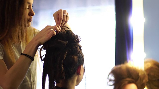 年轻的金发发型师给一个女人做发型视频下载