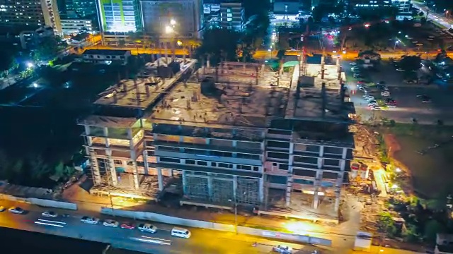 4k延时:建筑工地上起重机和工人在夜间的鸟瞰图视频素材