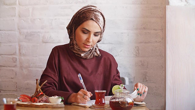 穆斯林女商人在咖啡馆工作文件视频素材