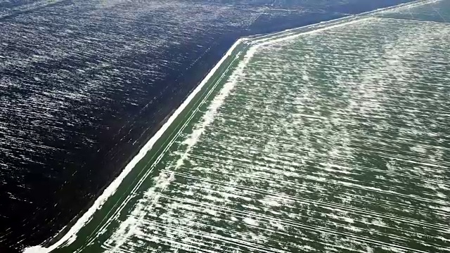 春季鸟瞰图中被雪覆盖的谷地。视频下载