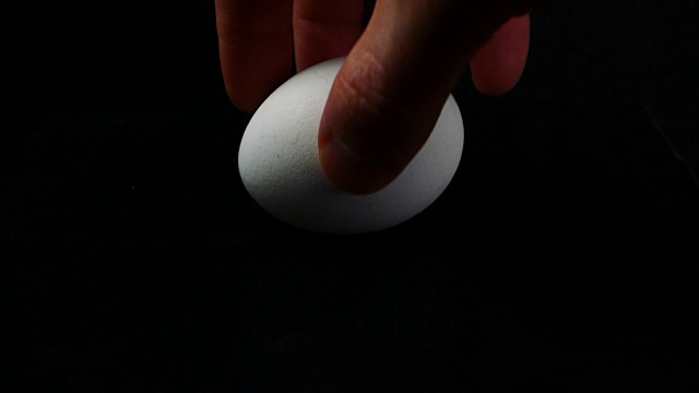 一个男人的手在桌子上翻转一个鸡蛋视频下载
