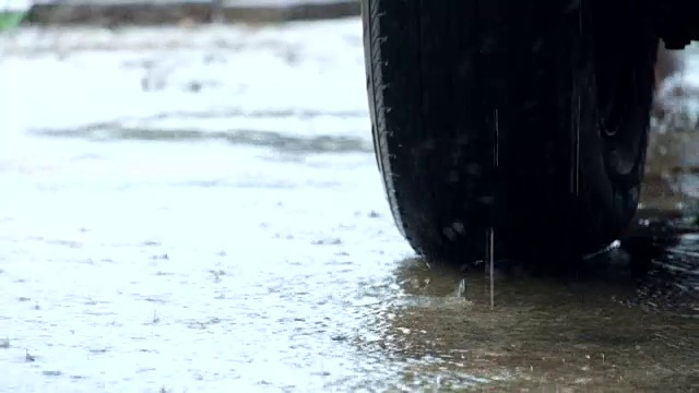 雨水和流水落在地面和轮胎背景上视频素材