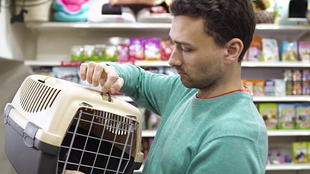 男人在宠物店挑选箱子来运送他的猫视频下载