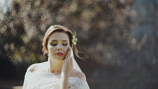 美丽的新娘穿着优雅的婚纱看着镜头，微笑着。视频素材