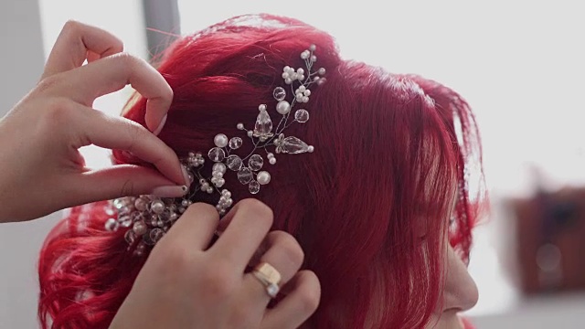 理发师的手把珠宝别在新娘的头发上视频素材