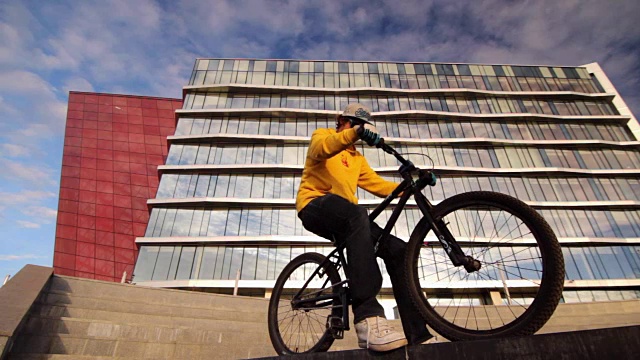 年轻人坐在自行车上。骑着自行车的人准备好了。城市自行车视频素材